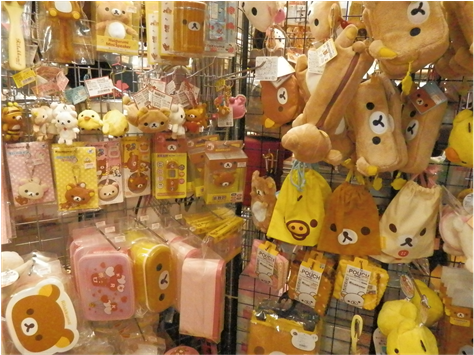 Various Products Bearing The Face Of Rilakkuma - Stuffed Toy (902x354), Png Download